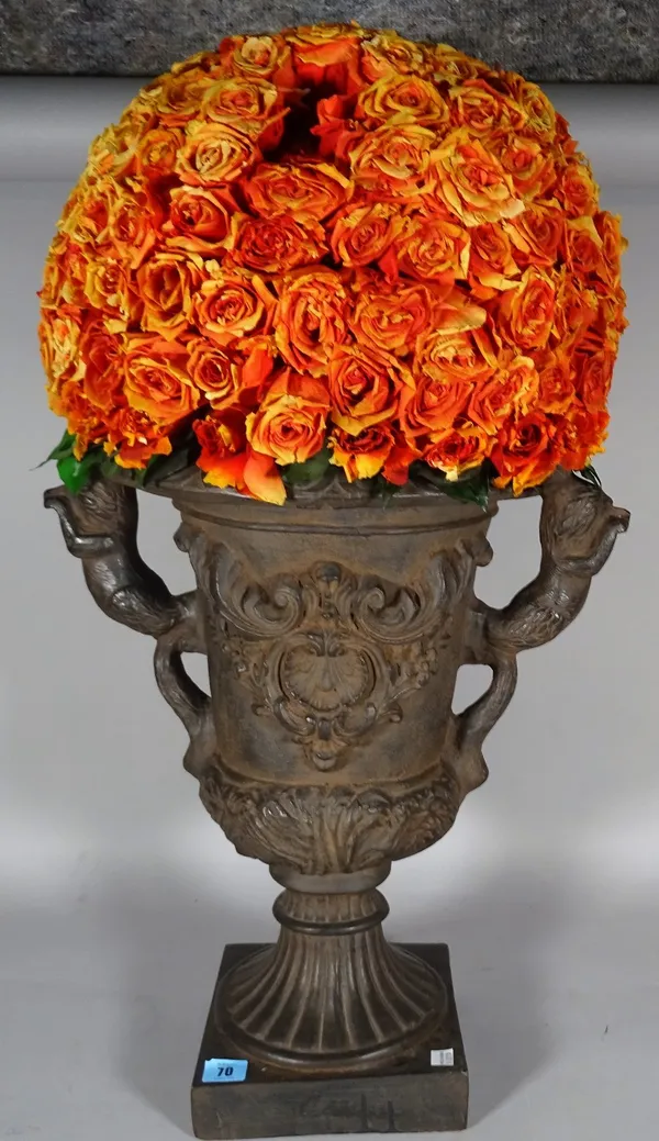 A Victorian style composite faux cast iron twin handled urn with an arrangement of dried orange roses, 76cm high. D4