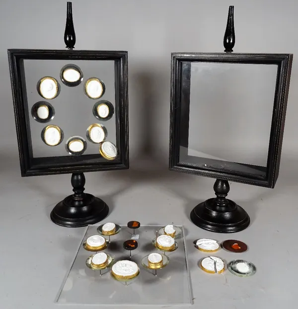 A modern black pedestal frame containing nine intaglios, (a.f.), and another similar, 24cm wide x 49cm high, (a.f.). CAB