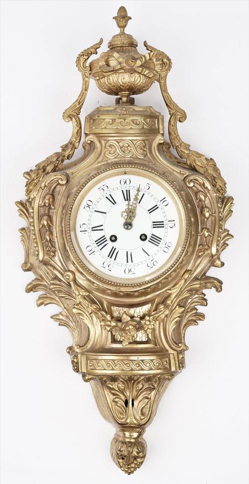 An 18th century style gilt metal cartel clock, 20th century with urn finial over a foliate cast case and white enamel dial enclosing a two train movem