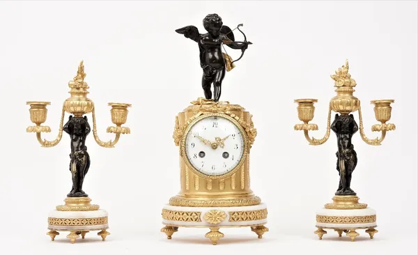 A French ormolu and white marble clock garniture, circa 1880, the clock surmounted by a bronze figure of cupid above ribbons and swags on a marble bas