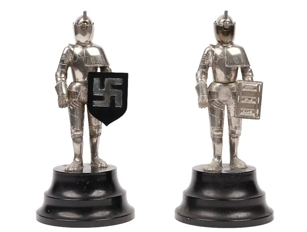 A pair of white figural table lighters, mid to late 20th century, each modelled as a knight in suit and armour, comprising a desk calender and a table