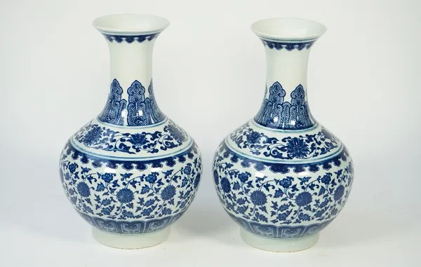 A pair of modern Chinese style blue and white porcelain vases, each foliate decorated against a baluster ground, printed mark to base, 30.5cm high, (2