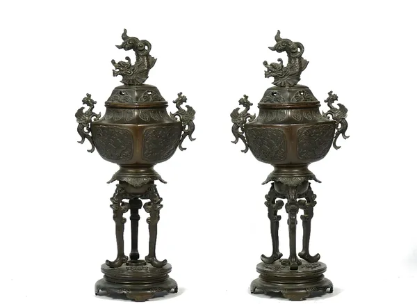 A pair of Japanese bronze vases and covers, early 20th century, each with dragon finial and pierced cover, raised on three long supports over a shaped