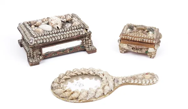 A 19th century seashell decorated vanity box and cover with mirrored sides, 19cm wide, a similar box and a hand mirror also decorated all over with se