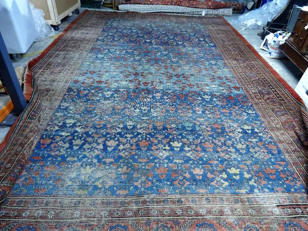 A Tabriz carpet, Persian, the mid indigo blue field with an allover pattern of stylised vases of angular flowers; a madder rosette, serrated leaf and