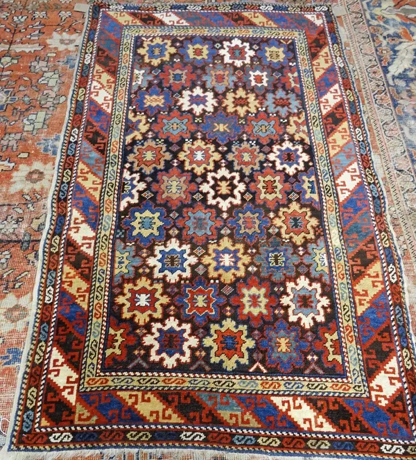 A Derbend rug, Caucasian, the dark walnut field with rows of stylised flowerheads in various colours; a banded hooked motif border, 166cm x 103cm.