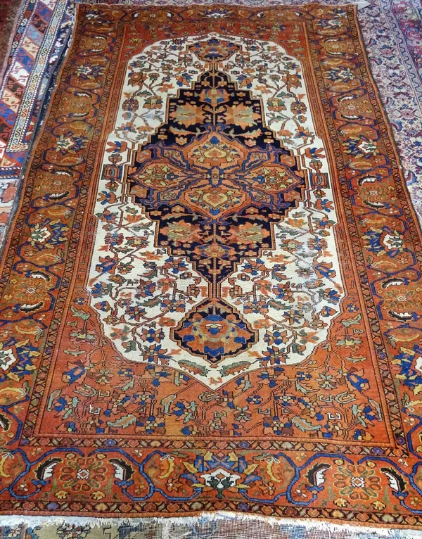 A Bakhtiari rug, Persian, the ivory field with a bold dark indigo medallion, centred by a madder medallion, all with angular floral vines; a madder pa