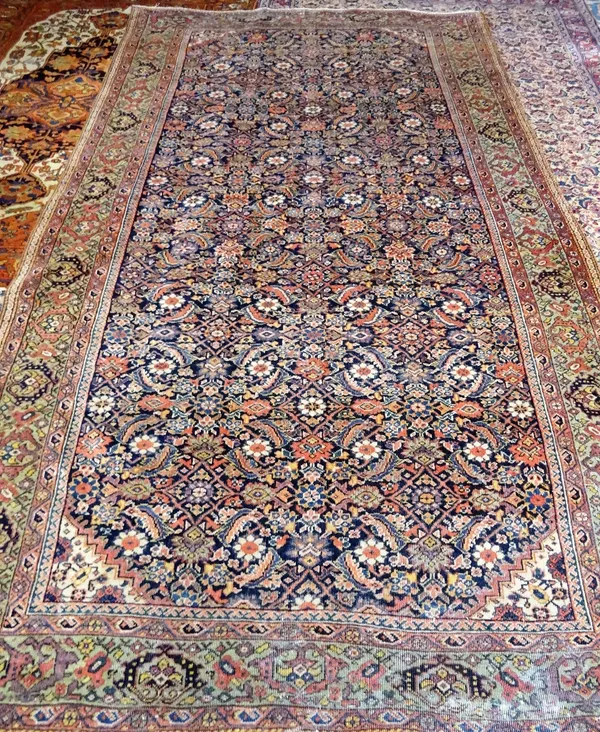 A Fereghan Kelleh carpet, Persian; the dark indigo field with an allover herate design; a sage palmette border, 289cm x 165cm.