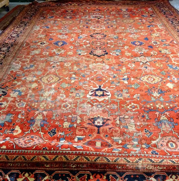 A Mahal carpet, Persian, the madder field with an allover design of bold flowerheads, palmettes and connecting floral sprays; a dark indigo palmette a