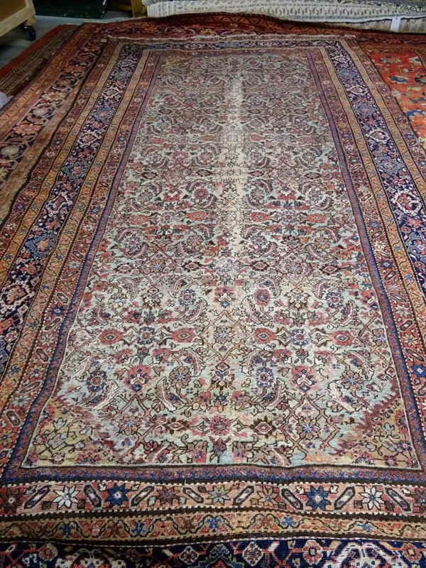 A Fereghan kelleh carpet, Persian, the sage field with an allover hearate design; an indigo palmette border, 377cm x 194cm.