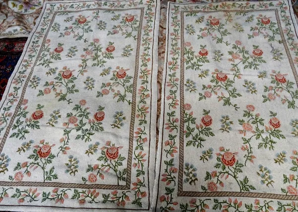 A pair of modern cross stitch decorative Portuguese rugs, each ivory field with delicate floral sprays, complementary border, 146cm x 88cm, (2).