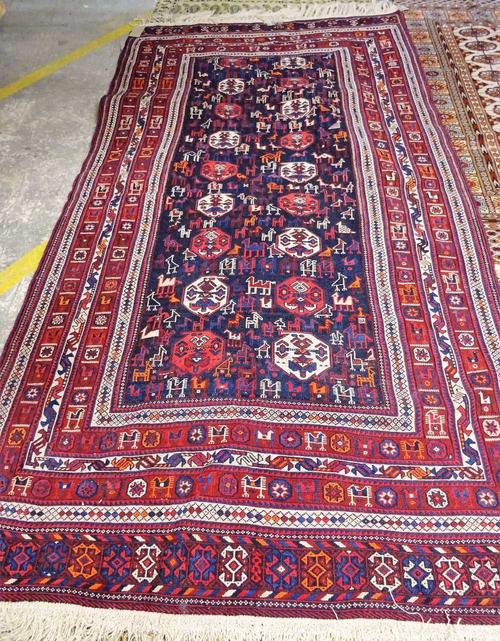 A South Persian soumak rug, the dark indigo field with ivory and madder boteh, birds, camels and goats; two bird section borders, end bands, 224cm x 1