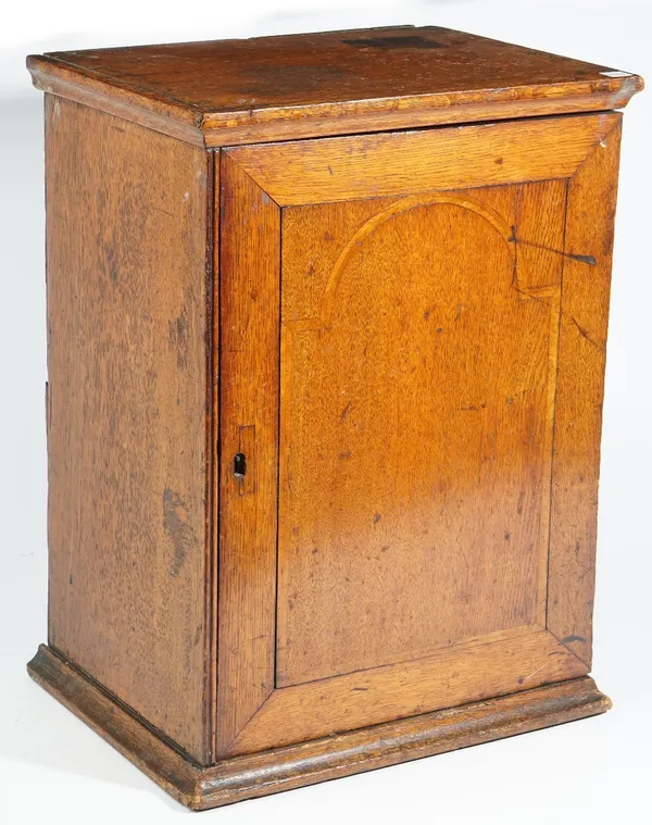 An 18th century inlaid oak hanging spice cupboard, the single door enclosing six drawers, 35cm wide x 48cm high.