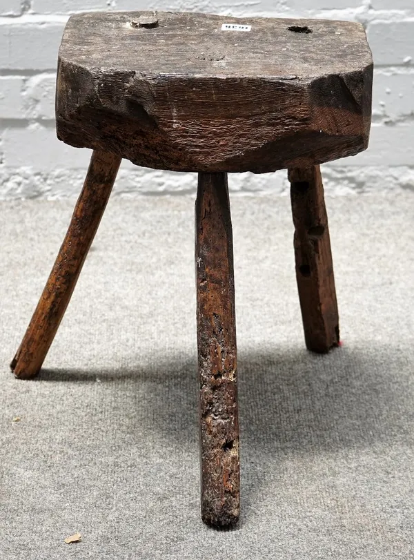 A 19th century primitive oak stool/chopping block, on three staked supports, 33cm wide x 44cm high.