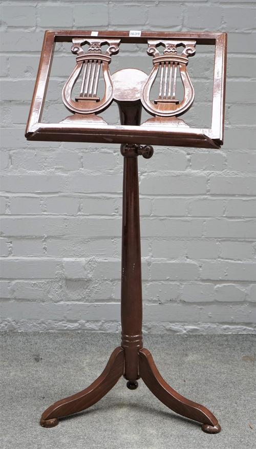 A Continental mahogany height adjustable sheet music stand, with double lyre decoration and tripod base, 51cm wide.