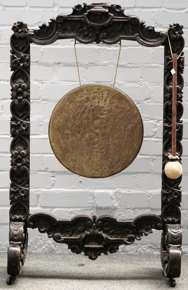 A Victorian dinner gong, in a carved oak frame, 64cm wide x 105cm high.