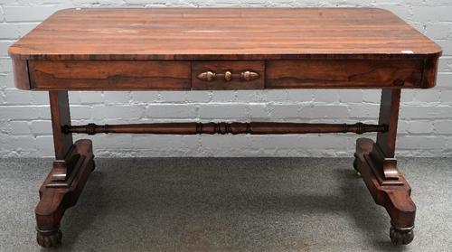 A William IV rosewood library centre table, the rounded rectangular top with a pair of flush fit frieze drawers, on slab trestle end standards and mel