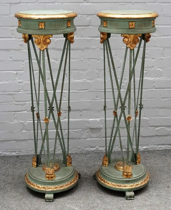 A pair of 18th century style parcel gilt green painted circular torchere stands, with open metal frames on scroll feet, 36cm diameter x 113cm high.