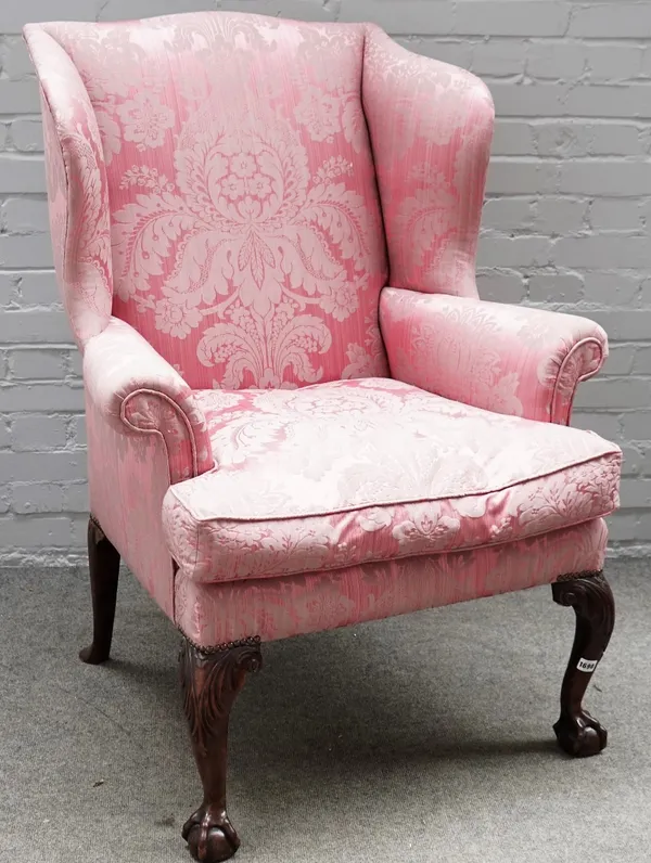 An 18th century wingback armchair, on walnut claw and ball feet, 90cm wide x 118cm high.