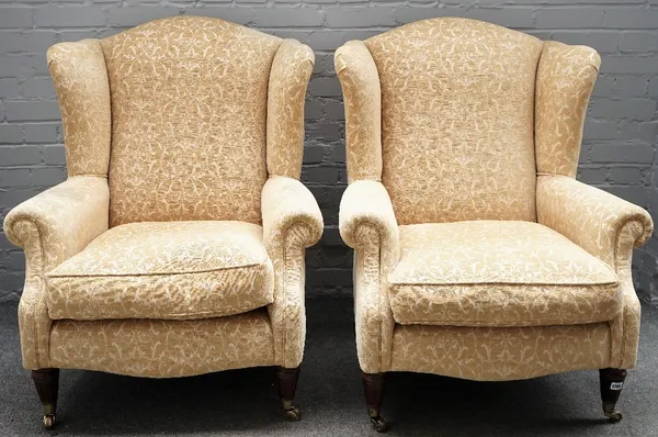 A pair of 20th century wingback armchairs, on tapering fluted supports, 80cm wide x 102 cm high.