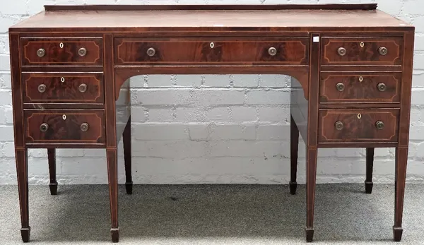 Probably Waring & Gillows; an inlaid mahogany seven drawer writing desk, on square supports, 137cm wide x 80cm high.