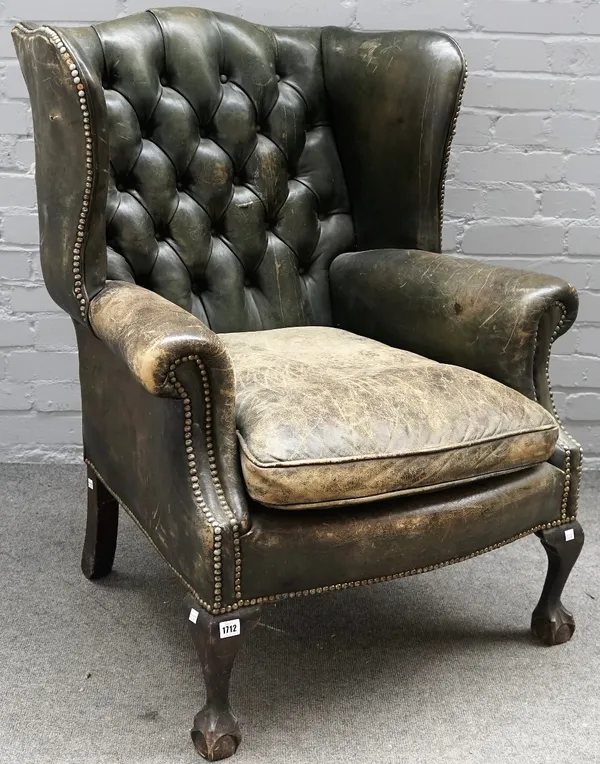 A George II style green leather upholstered wingback armchair, on claw and ball feet, 80cm wide x 103cm high.