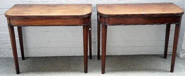 A pair of Regency mahogany card tables each with 'D' shaped tops and inlaid frieze on tapering square supports, 91cm wide x 71cm high.