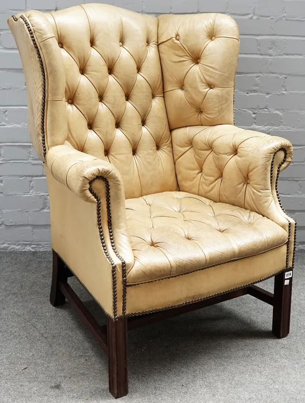 A mid-18th century style beige leather upholstered wingback armchair, on square supports, 80cm wide x 107cm high.