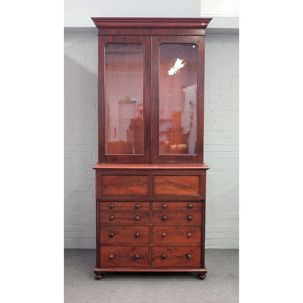 A Victorian mahogany secretaire display cabinet, the pair of glazed doors over fitted drawer, one long drawer and six short drawers on plinth base, 11