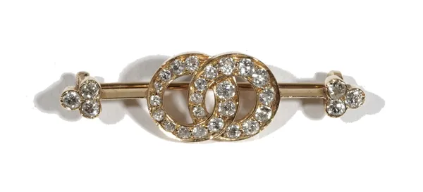 A late 19th century/early 20th century diamond-set bar brooch, set with old mine-cut diamond set in two interlinking circles, and trefoil diamonds to