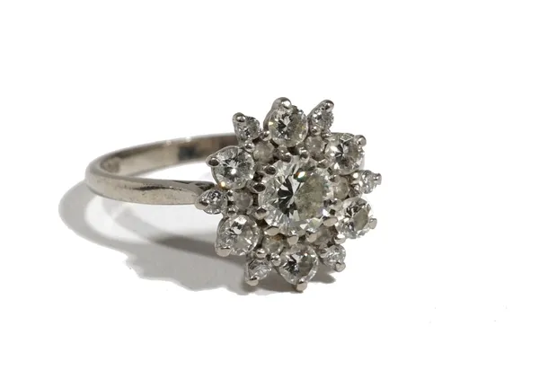 An 18ct white gold and diamond cluster ring of flowerhead design, the central round brilliant-cut diamond approximately 0.66ct, surrounded by six roun