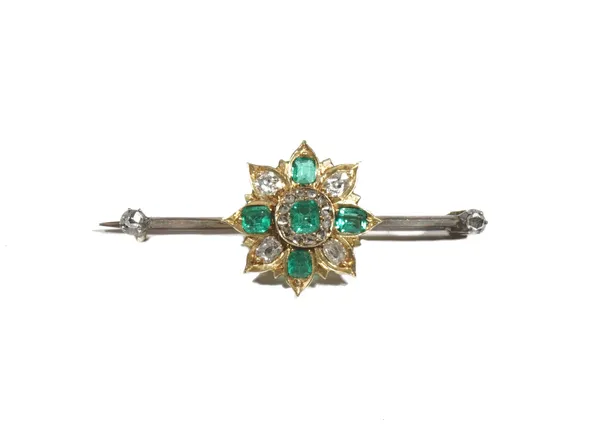 An emerald and diamond set bar brooch, of flowerhead design, claw set with step-cut, cut-cornered emeralds and old mine-cut diamonds, to a bar, with d