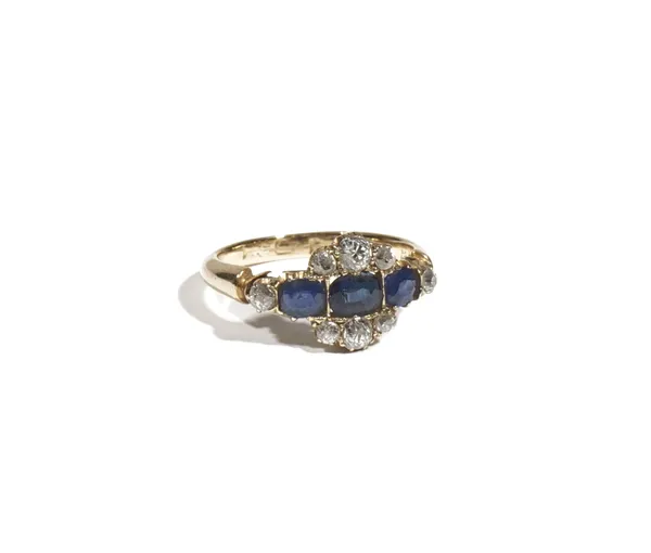 An 18ct gold, sapphire and diamond-set dress ring, set with three oval-cut sapphires, between six old mine-cut diamonds, set with diamonds to the shou