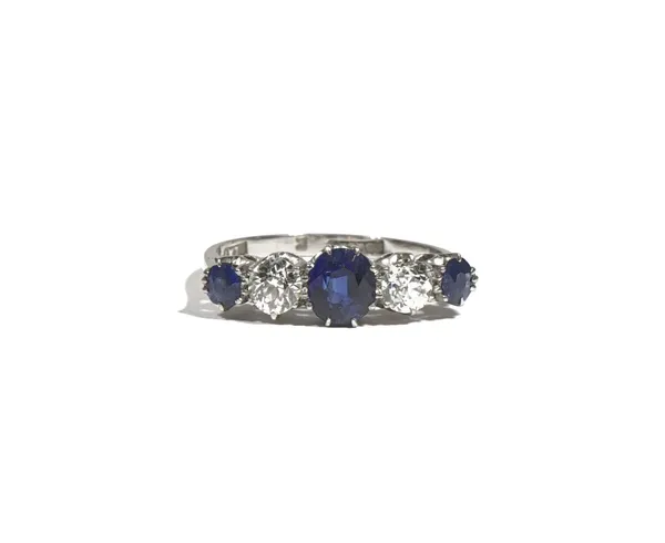 A platinum, sapphire and diamond-set five stone ring, claw-set with three oval-cut sapphires and with two old mine-cut diamonds, the shank marked for