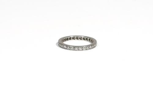 A diamond-set eternity ring, claw-set with circular-cut diamonds, to a white precious metal mount, ring size K, 2.6g gross.