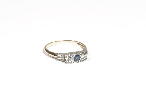 A gold, sapphire and diamond three-stone ring, the central circular-cut sapphire, between two similar sized circular-cut diamonds, claw set to a white