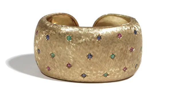 A gold and gem-set hinged torc bangle, star set with circular-cut sapphires, rubies and emeralds to a textured ground, detailed 18k, Italy, 74.5g gros