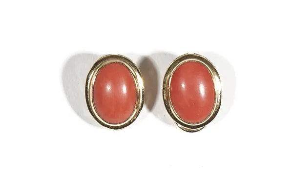 A pair of Italian gold and coral earclips, each mounted with an oval cabochon coral, detailed 750, gross weight 7.4 gms.