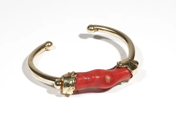 A gold and coral bangle, the front mounted with a section of branch coral (restored), detailed 750, gross weight 32.2 gms, with a blue pouch.