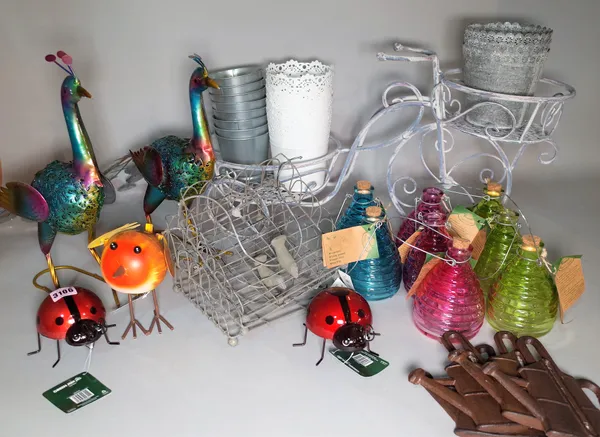 A group of 20th century decorative garden items, including metal peacocks, wasp catchers, a plant stand and sundry, (qty).