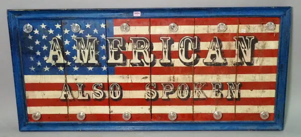 A modern hardwood sign with an American flag decoration 'AMERICAN ALSO SPOKEN', 131cm wide x 60cm high.