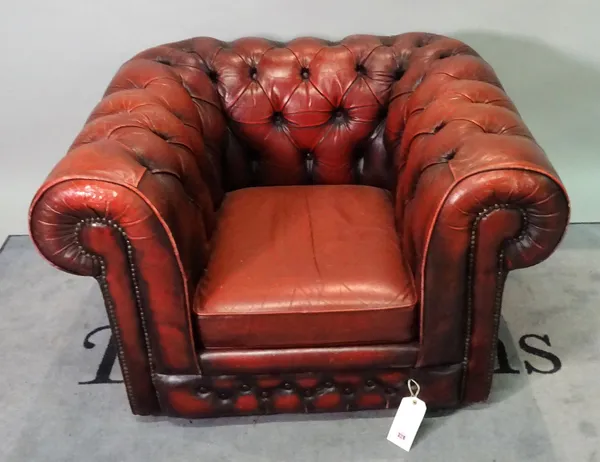 A 20th century red leather upholstered Chesterfield low armchair, 105cm wide x 75cm high.