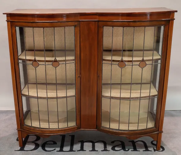 A late Edwardian mahogany serpentine display cabinet on square supports, 122cm wide x 113cm high.