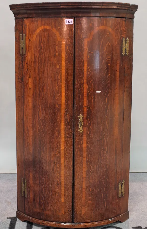 A late 18th century oak bowfront hanging corner cupboard, 60cm wide x 105cm high.