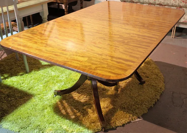 A Regency style mahogany extending dining table with a rectangular top on outswept supports, including two extra leaves, 180cm long x 72cm high (272cm