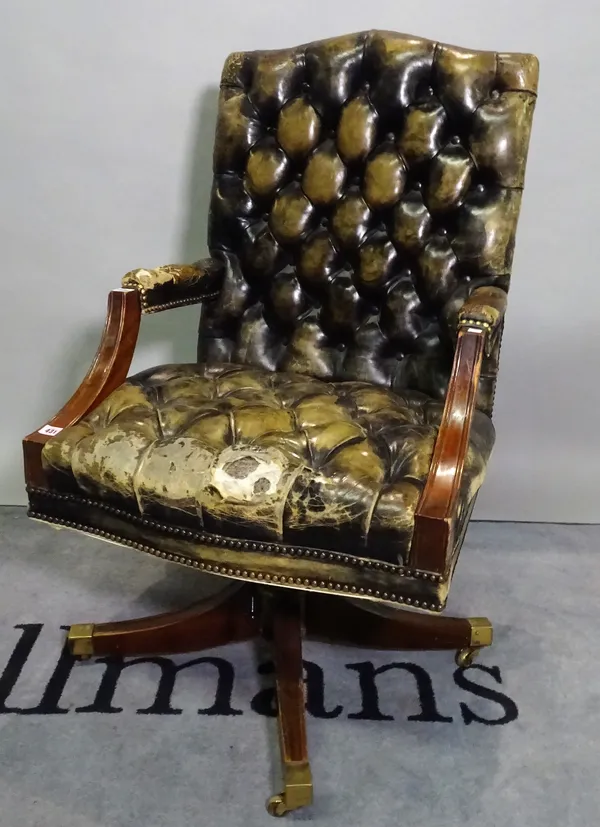 A studded green leather upholstery open arm office swivel chair on four downswept supports, 65cm wide x 105cm high.