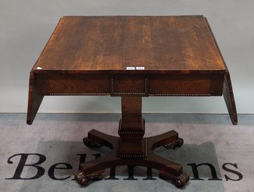 A 19th century mahogany drop flap sofa table with turned column and quatrefoil base, 91cm wide x 73 cm high.