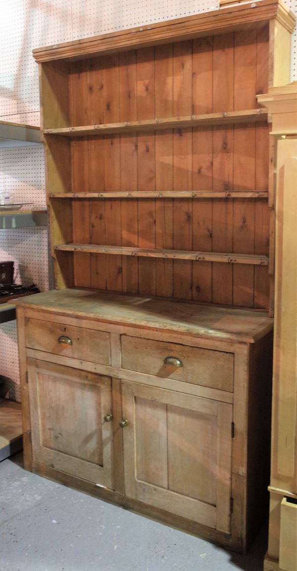 A 20th century pine dresser with three tier plate rack over cupboard base, 140cm wide x 240cm high.