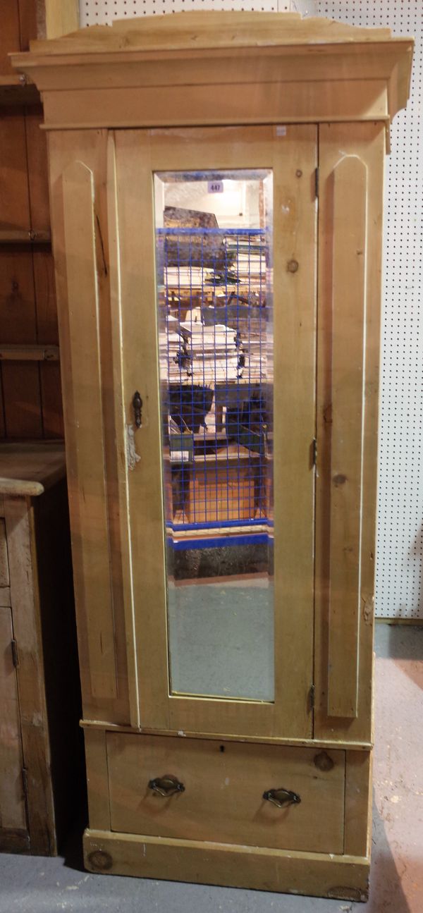 A 20th century pine single wardrobe with a central mirrored door over a single drawer on a plinth base, 79cm wide x 195cm high.