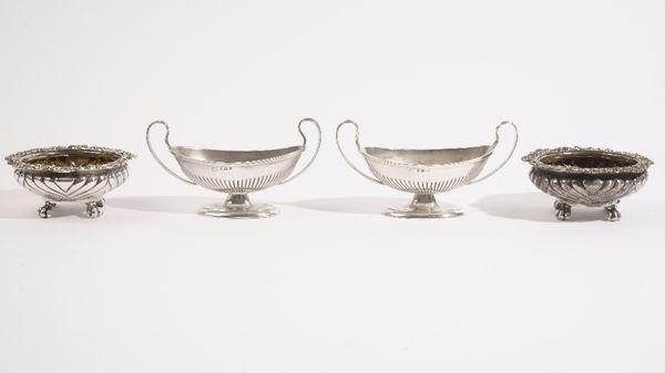 A pair of George IV silver salts, each of compressed circular form, with fluted decoration, decorated with a scrolled rim and raised on four feet, Lon